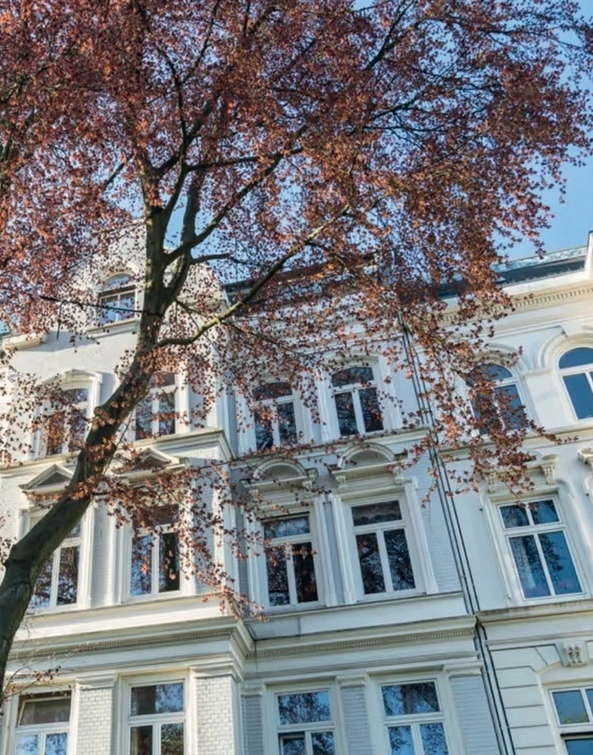 Pinar Herzog – Immobilien – Dieses Bild zeigt die schöne weiße Fassade eines traditionellen deutschen Altbaus. Herzog - Immobilien -